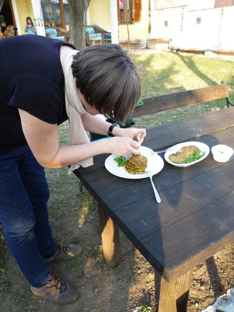 Petra Regner-Haindl arrangiert auf einem Tisch ein Teller mit Wildkräuterpuffer für das Weinviertler Wildkräuterbuch